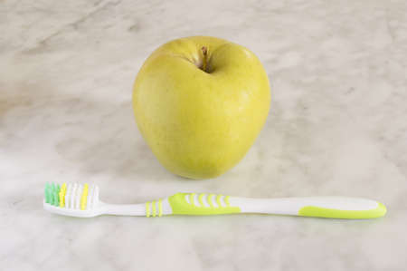 Apples with a toothbrush isolated on marbleの写真素材