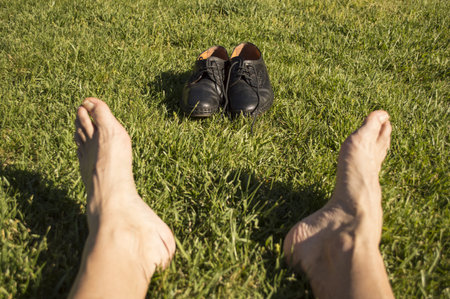 feet relaxing in the grass with his shoes