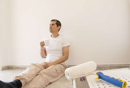 relaxed painter taking a tea sitting on the floorの写真素材