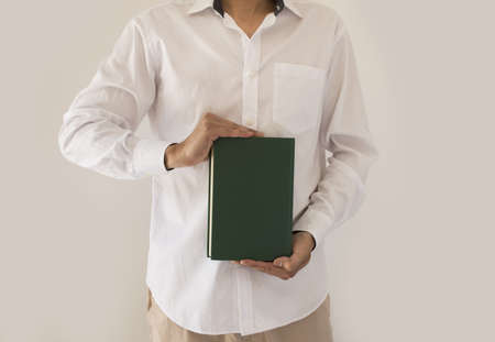 man holding up book with green empty book coverの写真素材