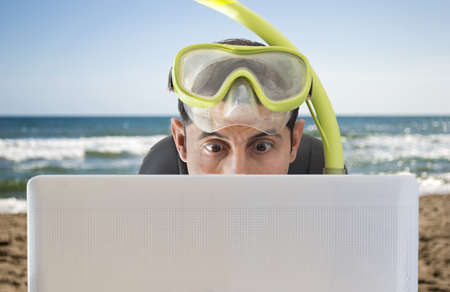  Man surprised by the bid prices on the web for holidays and trips on the beachの写真素材