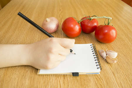 write in Notebook and Fresh Vegetables Background Diet in tableの写真素材