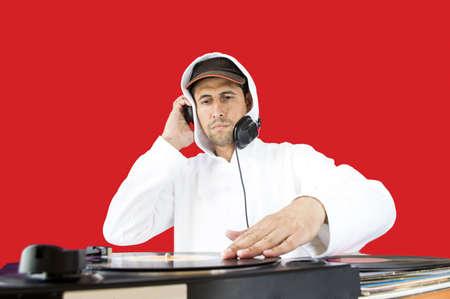 DJ mixing vinyl record on a  turntable with red backgroundの写真素材