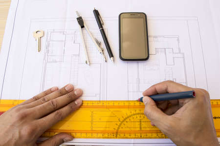 architect designing a plane with tools and a mobileの写真素材