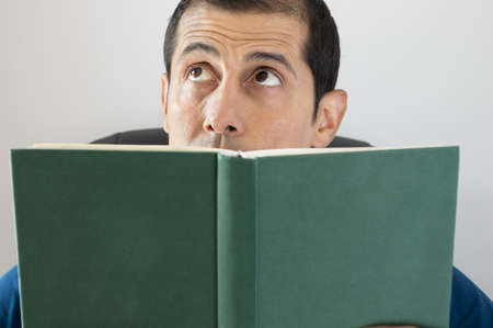 man reading a book and imagining the story toldの写真素材