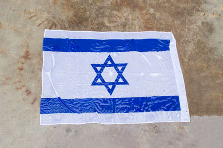 israel flag on the ground in the rainの写真素材