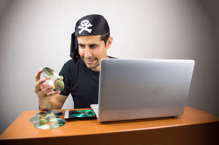 informatic hacker stealing music and recording it on compact dishの写真素材