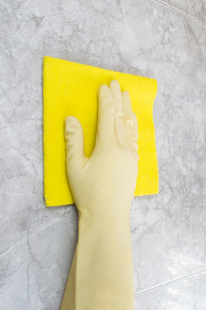 close up of a woman cleaning with a damp wall