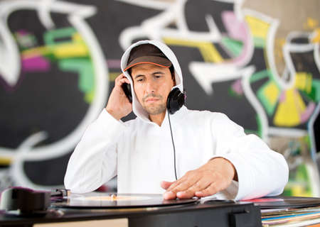 DJ mixing vinyl record on a  turntable with red backgroundの写真素材