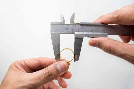 Goldsmith measuring gold ring with vernier caliperの写真素材