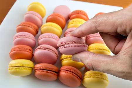 hands catching a big plate of macaronsの写真素材