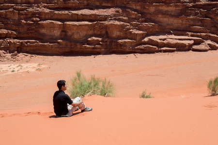 man hiker enjoying view sitting looking over of the desertの写真素材