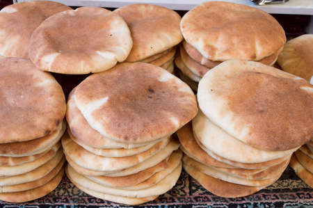 stacks of pita bread on a blanket to saleの写真素材