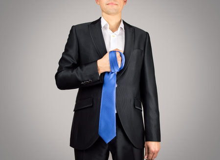 boyfriend with a tie in hand to tie your partner to practice masochism gray backgroundの写真素材