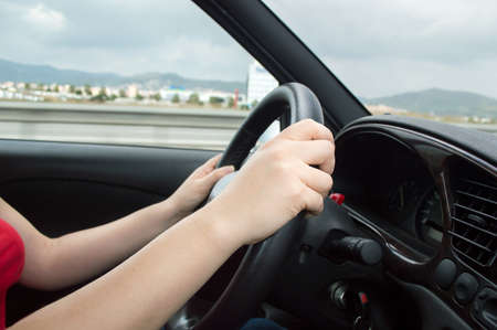 closeup of hands of a woman driving a carの写真素材