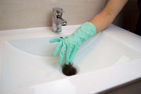 female taking a bunch of hair loss on the bathroomの写真素材