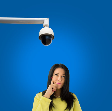 Woman suspected to be spied looking up at security camera