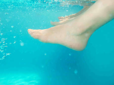 close up of women resting with feet in water with copyspaceの写真素材
