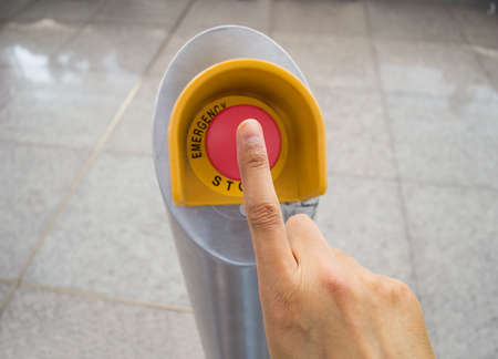 Hand pushing red emergency stop buttonの写真素材