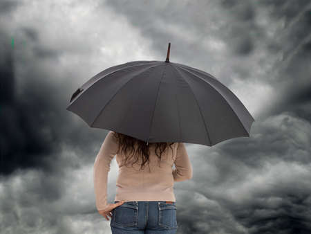 woman with umbrella standing in the rainの写真素材
