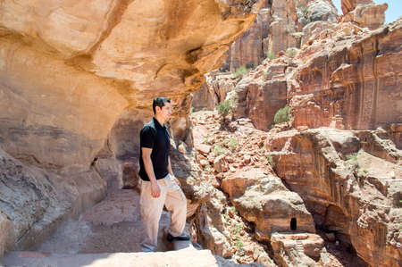 hiker man enjoying view looking at rock during hike in petra jordanの写真素材