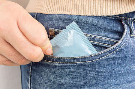 cropped  shot of a woman s pocket taking the condomの写真素材