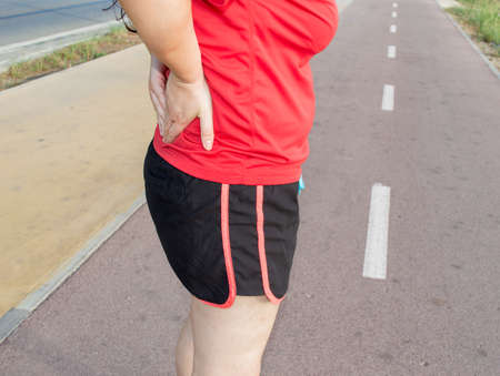 woman exercising and injuring backの写真素材