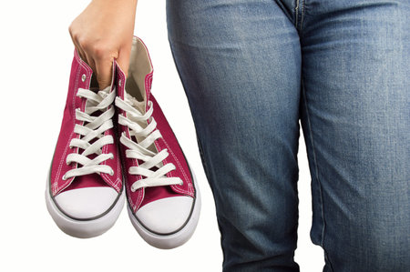 woman holding a shoe in hand and relaxed with white background