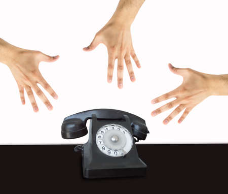 Group of hands grabbing an old phone with white backgroundの写真素材