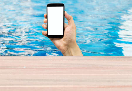 human hand showing a cellphone in a poolの写真素材