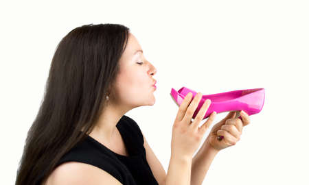 Attractive woman giving a kiss pink heeled shoesの写真素材