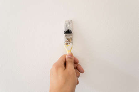 detail of hand painting white wall with the brushの写真素材