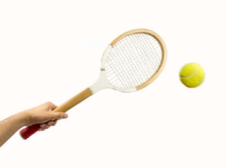Man hand holding vintage racket over dark background and ballの写真素材