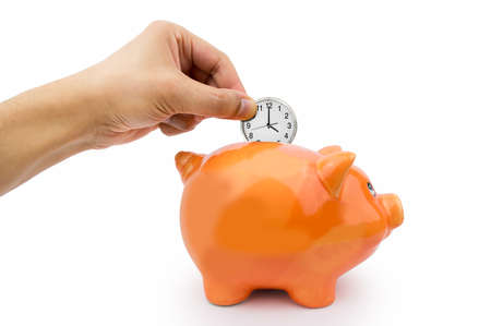 hand holding a clock ticking into the piggy bank