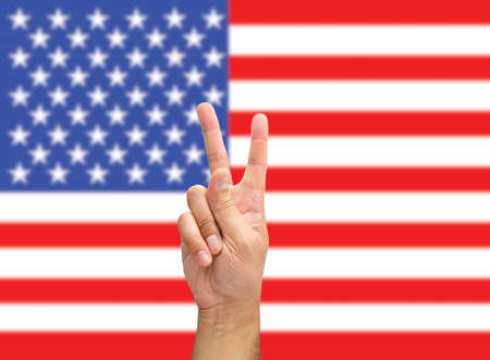 hand with two fingers in victory concept with flag of USA backgroundの写真素材