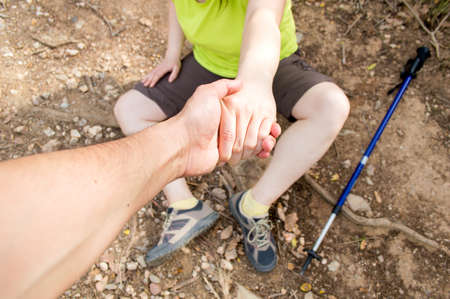 detail of man helping with his hand to lift the woman fell in accident at the mountainの写真素材