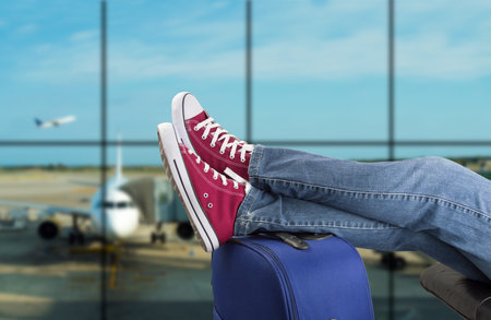 young man waiting for the plane at an airportの写真素材