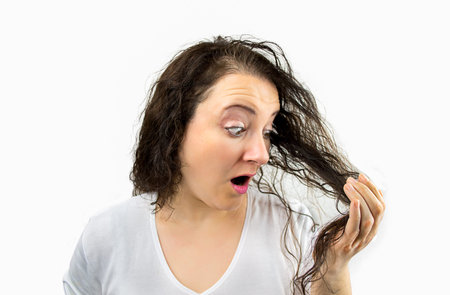 woman looking at her tangled hair isolated over a white background