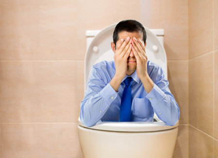 failed businessman in a toilet in concept of failure