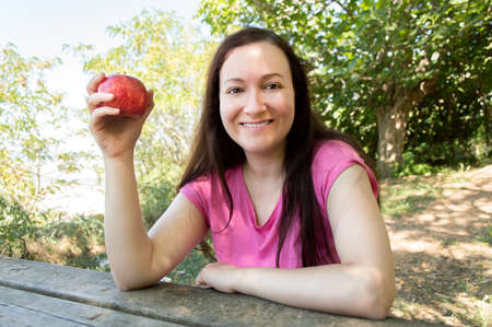woman hiker resting and eating an apple sittingの写真素材