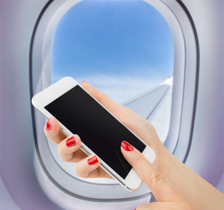 woman connected with your smartphone to the wireless network in a plane
