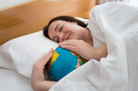 woman dreaming about traveling around the world while you sleepの写真素材