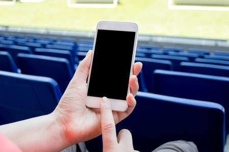 detail of people using smartphone in the soccer stadiumの写真素材