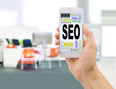 cloud of words or tags related to SEO in smartphone at the officeの写真素材