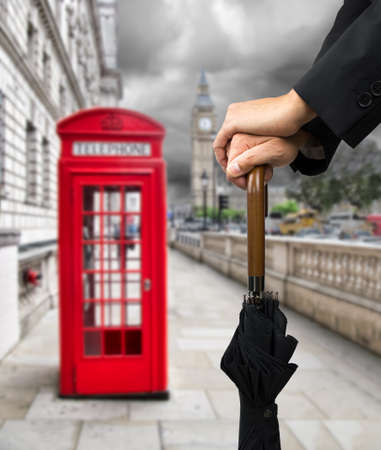 hands on an umbrella with a stormy sky in Londonの写真素材