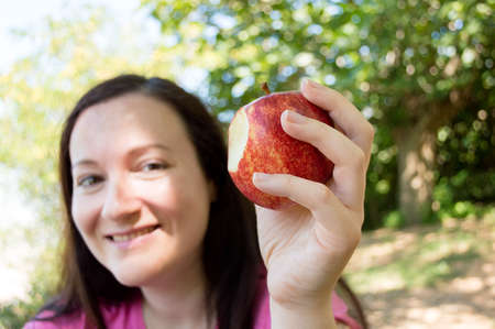 woman hiker resting and eating an apple sittingの写真素材