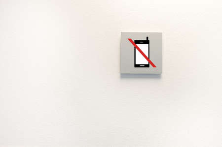 mobile phones sign isolated in wall background with copy space.All screen content is designed by us and not copyrighted by others and created with digitizing tablet and image editorの写真素材