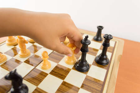 hand of a kid playing chess moving the rook to kill the king - making the checkmateの写真素材
