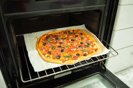 closeup of a pizza baked in the oven rackの写真素材
