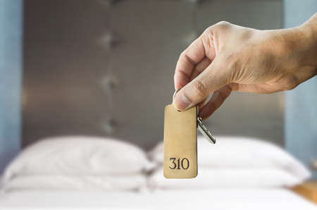 guest holding the hotel room key at the hotel suiteの写真素材